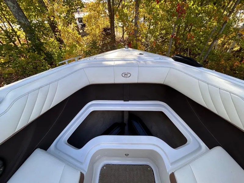 Slide: The Image of 2012 Cobalt 232 Bowrider boat interior with white seating and storage compartment. - 38