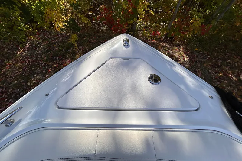 Slide: The Image of 2012 Cobalt 232 Bowrider boat bow, white surface, surrounded by autumn foliage. - 41