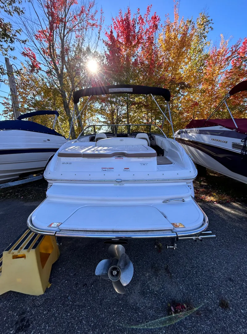 Slide: The Image of 2012 Cobalt 232 Bowrider boat parked outdoors with autumn trees in the background. - 5