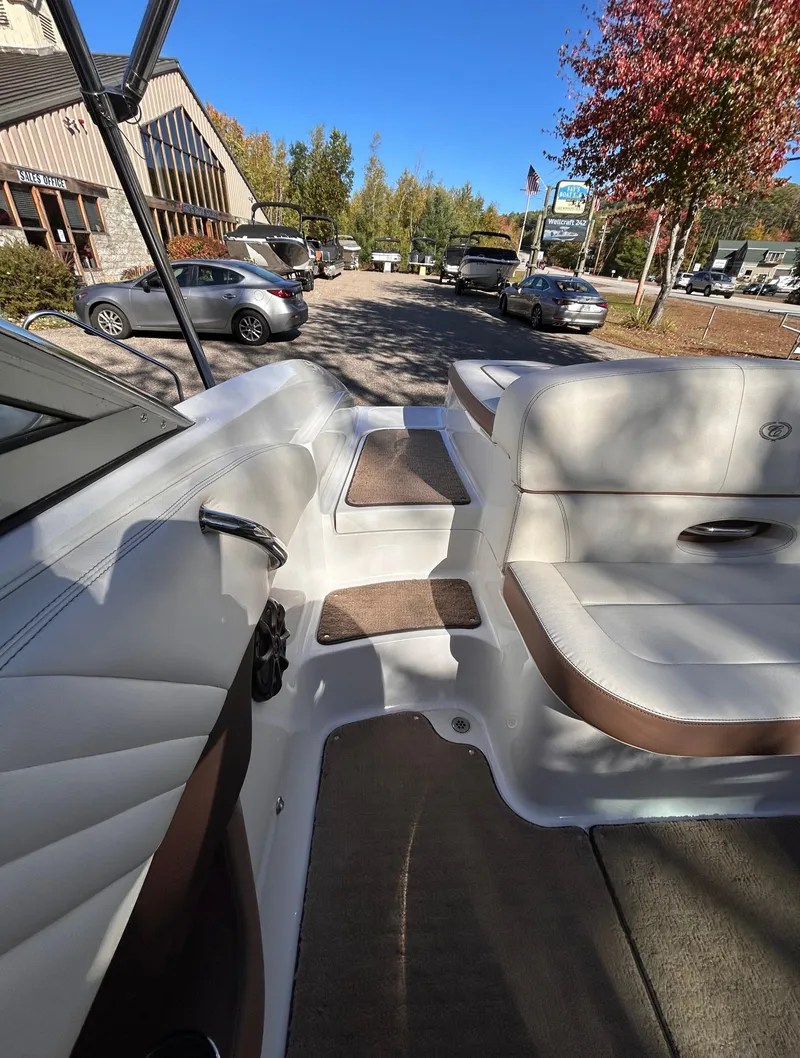 Slide: The Image of 2012 Cobalt 232 Bowrider interior with beige seating and outdoor view. - 9