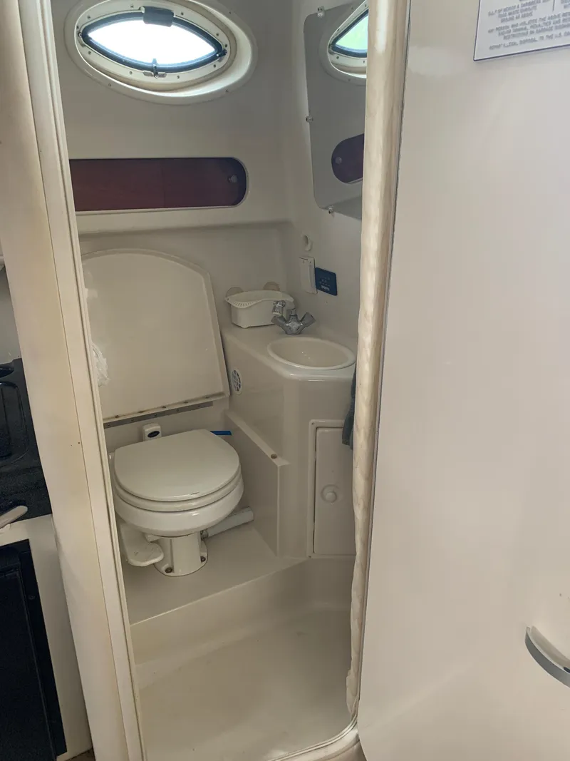 Slide: The Image of Compact bathroom in 2006 Monterey 302 Cruiser with toilet, sink, and porthole window. - 13