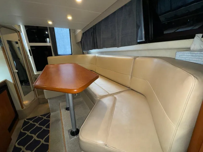 Slide: The Image of Interior of 2005 Bayliner 288 Classic with beige seating and wooden table. - 12