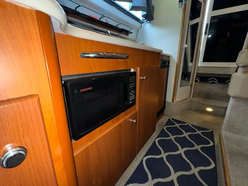 Slide: The Image of 2005 Bayliner 288 Classic interior with microwave and wooden cabinetry. - 8