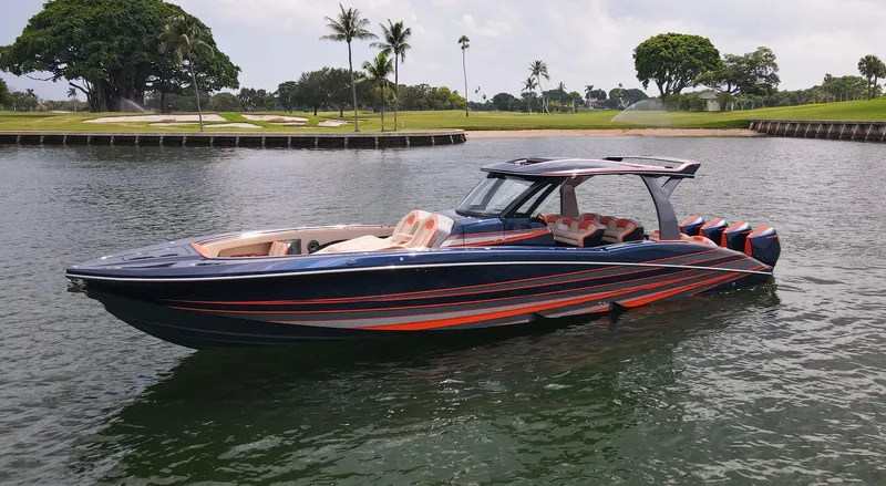Slide: The Image of 2024 MTI V42 boat with sleek design on a calm lake, surrounded by lush greenery. - 0
