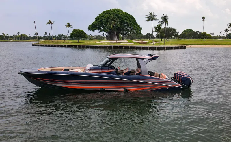 Slide: The Image of 2024 MTI V42 boat on water near tropical shoreline with palm trees. - 2