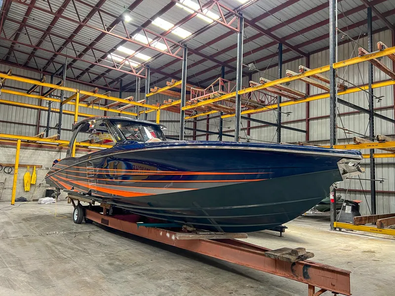 Slide: The Image of 2024 MTI V42 boat with sleek design and orange accents in a warehouse setting. - 26