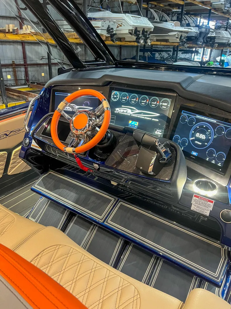 Slide: The Image of 2024 MTI V42 boat dashboard with advanced digital displays and orange steering wheel. - 5