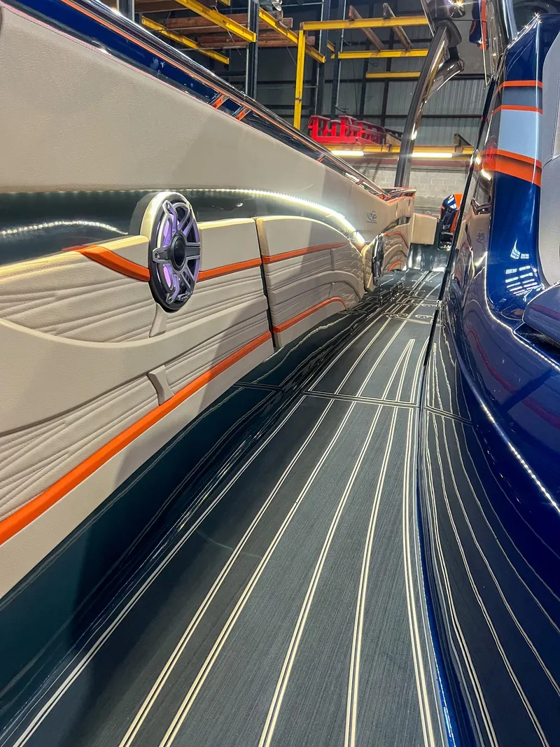 Slide: The Image of 2024 MTI V42 boat with sleek design and vibrant orange accents in a showroom. - 6