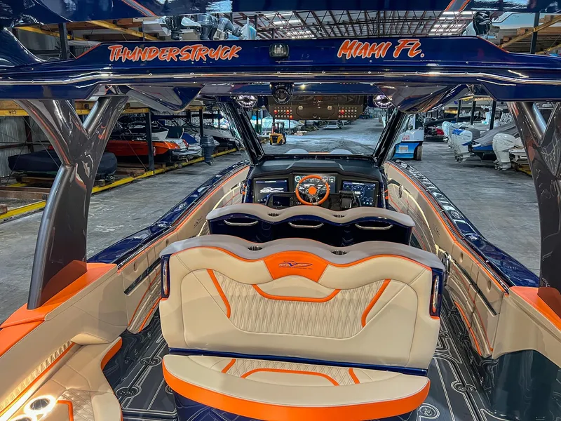 Slide: The Image of 2024 MTI V42 boat interior with orange and blue accents, docked in Miami, Florida. - 8