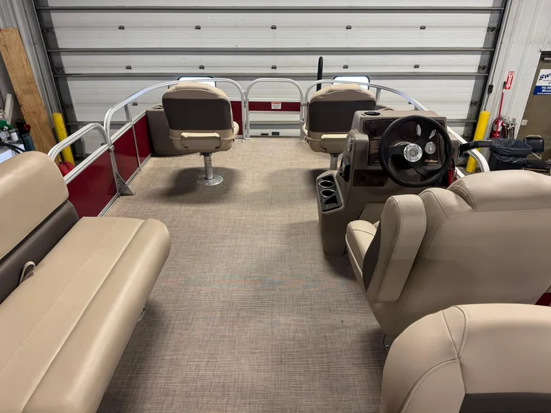 Slide: The Image of 2025 Sun Tracker Bass Buggy 18 DLX pontoon boat interior with beige seating and steering console. - 11