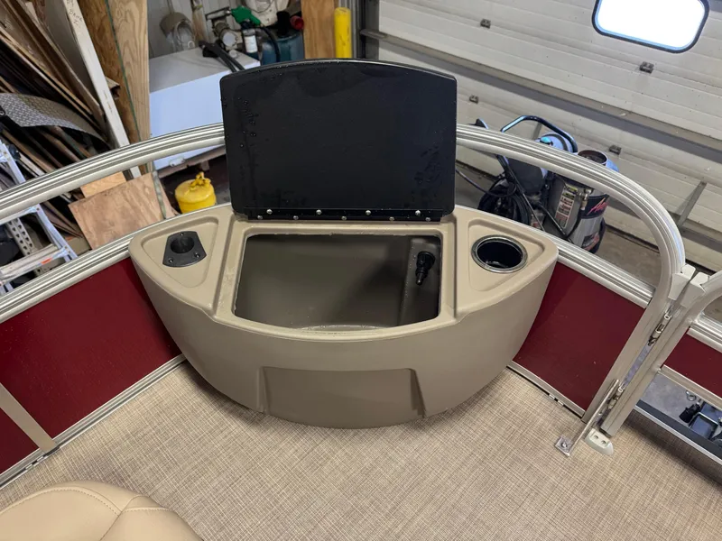 Slide: The Image of 2025 Sun Tracker Bass Buggy 18 DLX boat storage compartment with cup holder and beige interior. - 9