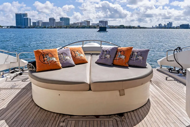 Slide: The Image of Sunseeker Predator 75 yacht deck with cushions, overlooking city skyline and ocean. - 8