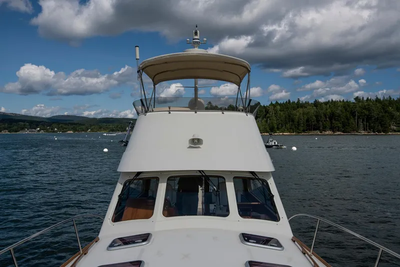 Slide: The Image of 2006 Hinckley Talaria 44 FB yacht on calm water with scenic forest backdrop. - 13