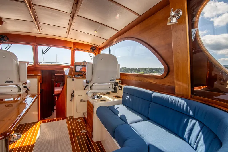 Slide: The Image of Interior of 2006 Hinckley Talaria 44 FB yacht with blue seating and wooden accents. - 28