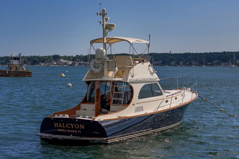 Slide: The Image of 2006 Hinckley Talaria 44 FB yacht on water, named "Halcyon," with scenic background. - 3