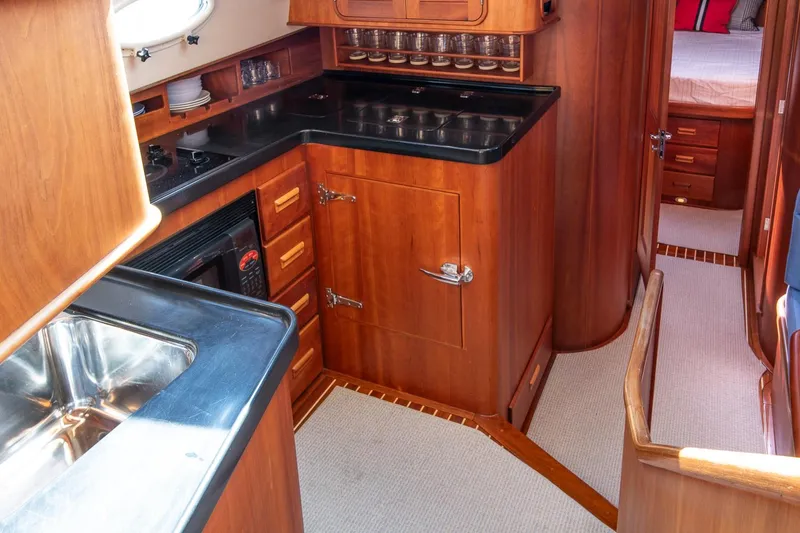 Slide: The Image of Luxurious 2006 Hinckley Talaria 44 FB yacht interior with elegant wood cabinetry and modern kitchen amenities. - 35