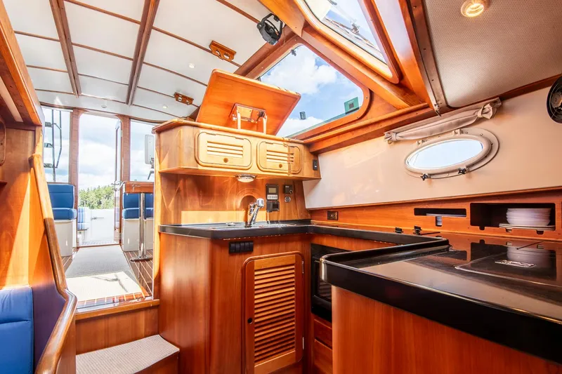 Slide: The Image of Interior of 2006 Hinckley Talaria 44 FB yacht, featuring a wooden kitchen and skylight. - 36