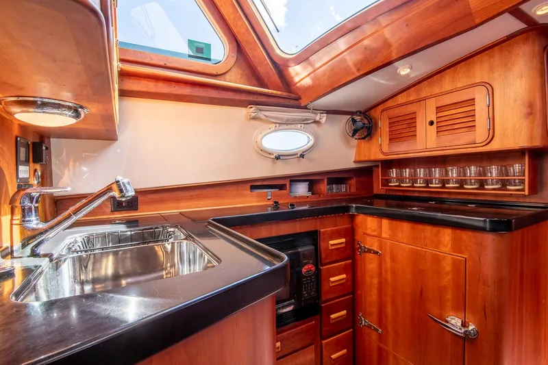 Slide: The Image of Luxurious 2006 Hinckley Talaria 44 FB yacht kitchen with wood cabinetry and modern amenities. - 37