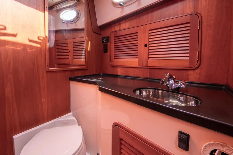 Slide: The Image of 2006 Hinckley Talaria 44 FB yacht bathroom with wood cabinetry and stainless steel sink. - 43