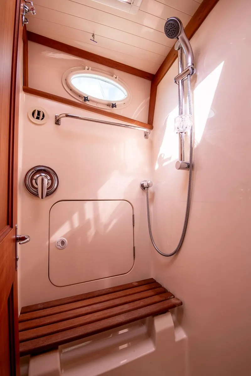 Slide: The Image of Shower area in 2006 Hinckley Talaria 44 FB yacht with wooden bench and porthole. - 46
