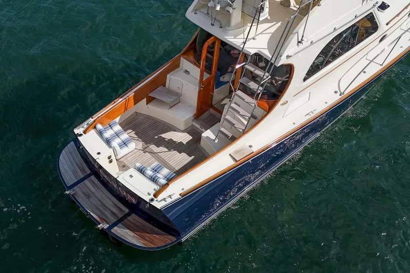 Slide: The Image of 2006 Hinckley Talaria 44 FB yacht on water, featuring elegant deck and seating area. - 6