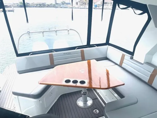 Slide: The Image of 2022 Beneteau 32 Gran Turismo yacht interior with sleek seating and polished wood table. - 11