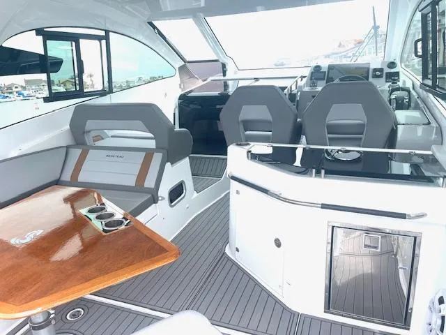 Slide: The Image of Interior of 2022 Beneteau 32 Gran Turismo yacht with modern seating and wooden table. - 13