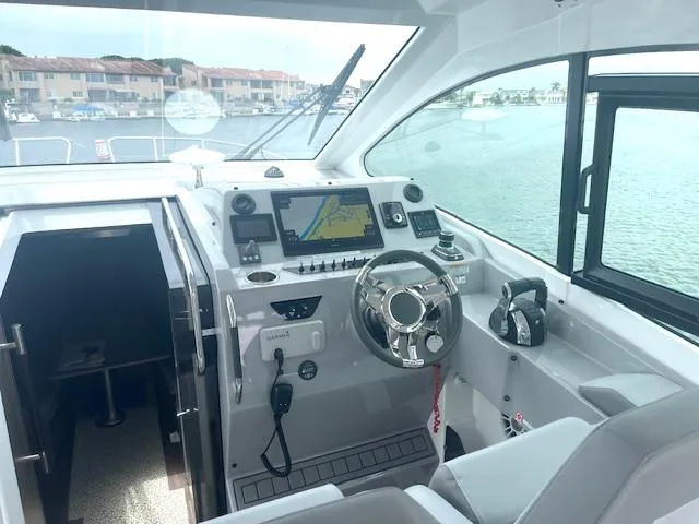 Slide: The Image of 2022 Beneteau 32 Gran Turismo helm with navigation system and waterfront view. - 21