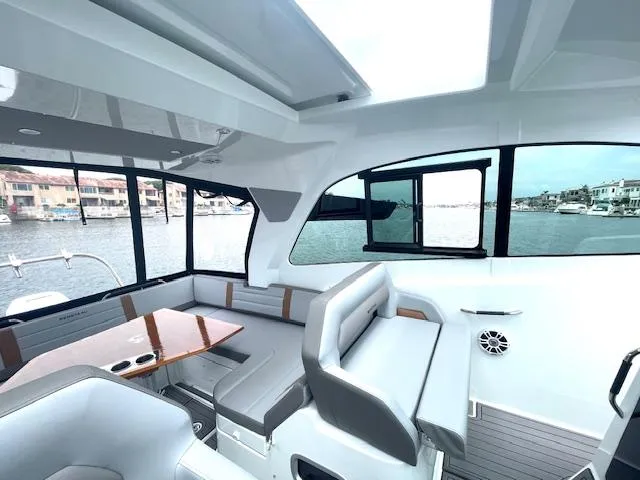 Slide: The Image of Interior of 2022 Beneteau 32 Gran Turismo yacht with modern seating and waterfront view. - 24