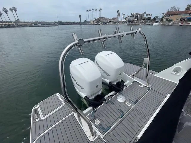 Slide: The Image of 2022 Beneteau 32 Gran Turismo with dual Mercury outboard engines on a calm waterfront. - 27