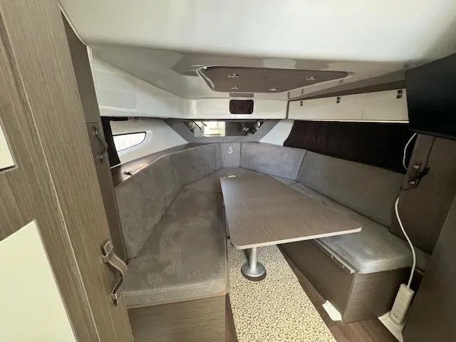 Slide: The Image of Interior of 2022 Beneteau 32 Gran Turismo yacht, featuring a cozy seating area and table. - 3