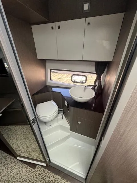 Slide: The Image of Modern bathroom in 2022 Beneteau 32 Gran Turismo yacht with sink, toilet, and storage cabinets. - 4
