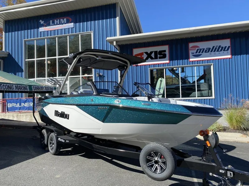 The Image of 2025 Malibu 23 LSV boat displayed outside dealership. - 1