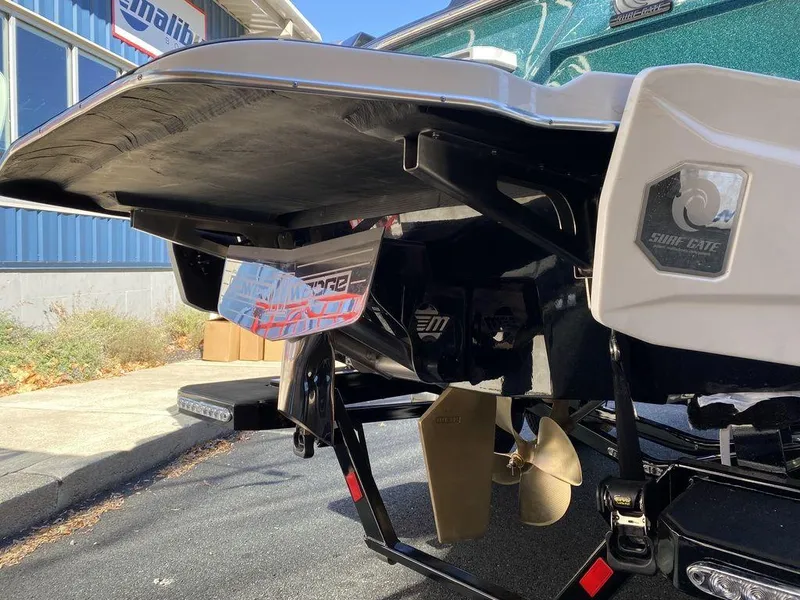 Slide: The Image of 2025 Malibu 23 LSV boat rear view with propeller and surf gate. - 4