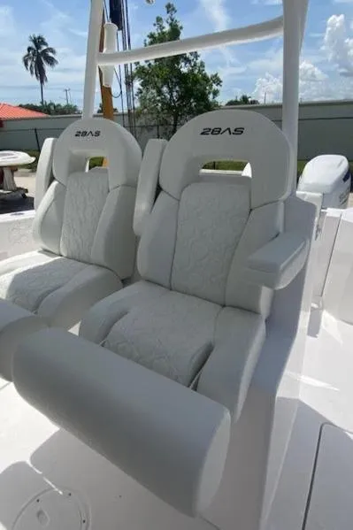 Slide: The Image of 2025 Aquasport 2800 AS boat seats, white upholstery, outdoor setting. - 5
