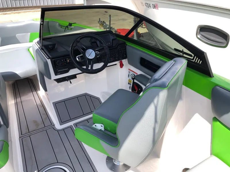 Slide: The Image of 2018 Moomba Max boat interior with green accents and modern steering console. - 10