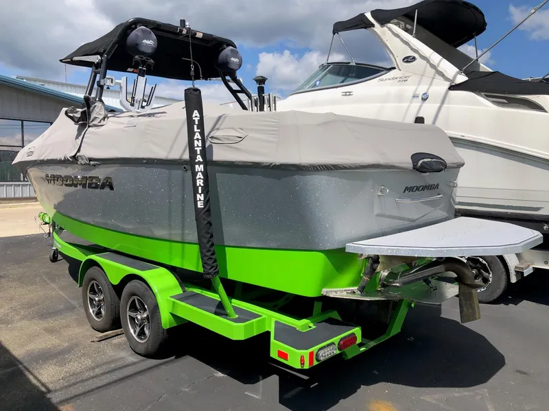 Slide: The Image of 2018 Moomba Max boat with cover on a vibrant green trailer. - 3