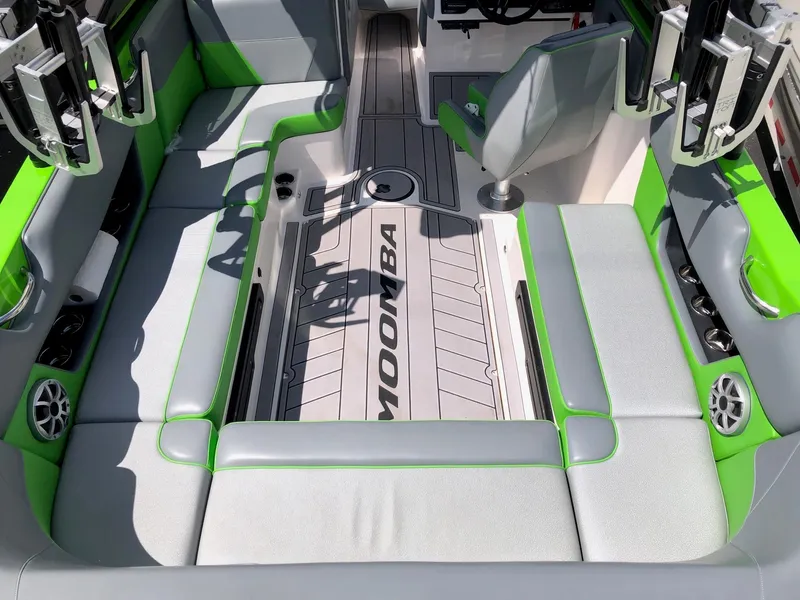 Slide: The Image of 2018 Moomba Max boat interior with green accents and seating. - 8
