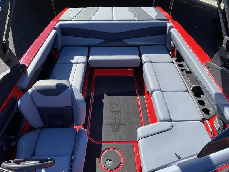 Slide: The Image of 2025 Axis A225 boat interior with gray and red seating, cup holders, and steering wheel. - 14