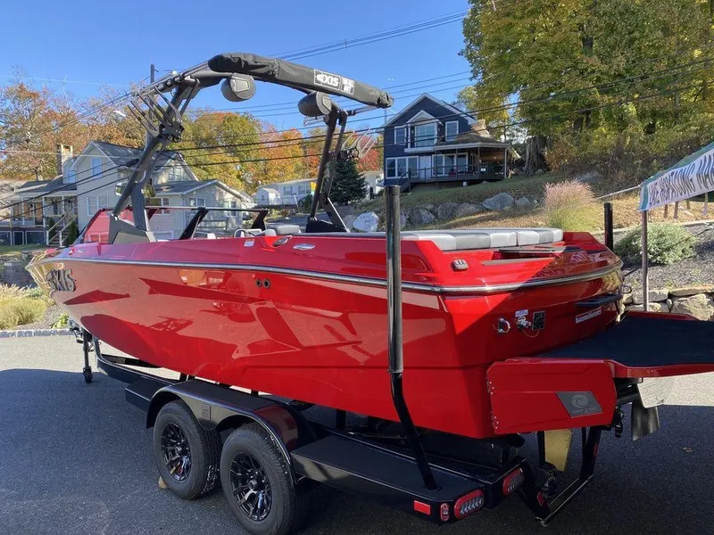 Slide: The Image of Red 2025 Axis A225 boat on trailer, parked near houses and trees. - 5