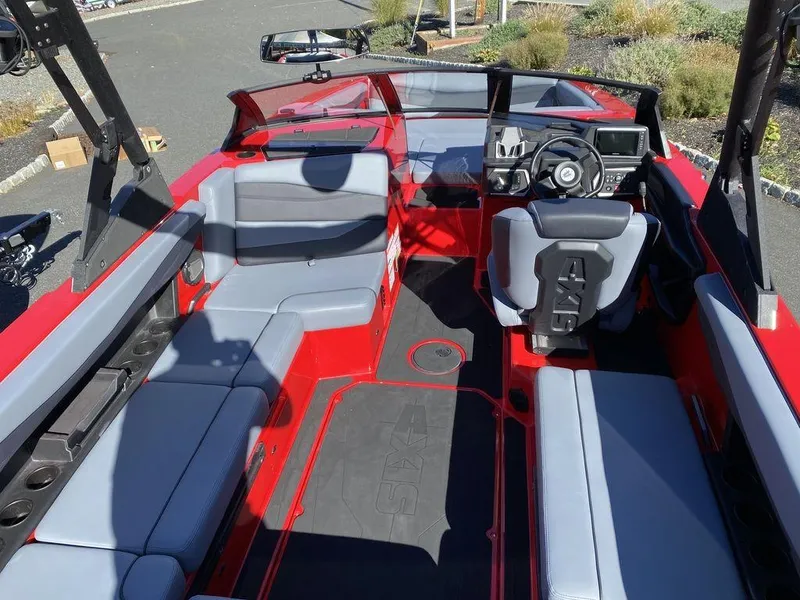 Slide: The Image of 2025 Axis A225 boat interior with red and gray seating, modern dashboard, and spacious layout. - 9