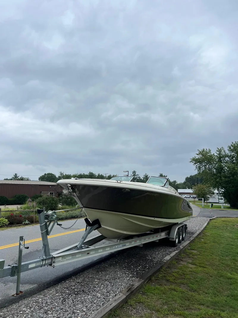 Slide: The Image of 2014 Chris-Craft 32 Launch boat on trailer under cloudy sky. - 12