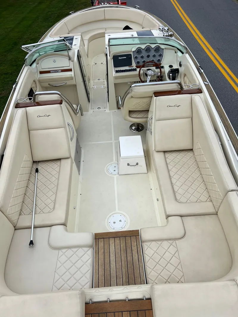 Slide: The Image of 2014 Chris-Craft 32 Launch boat interior with beige seating and wooden accents. - 16