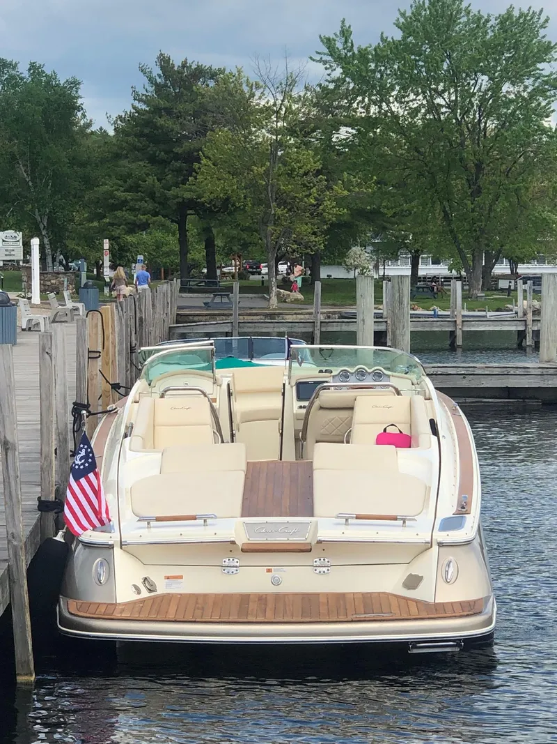Slide: The Image of 2014 Chris-Craft 32 Launch docked, featuring elegant design and American flag. - 20