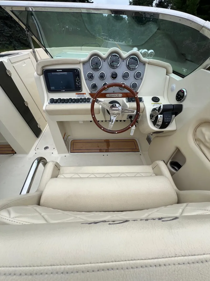 Slide: The Image of 2014 Chris-Craft 32 Launch boat cockpit with leather seating and wooden steering wheel. - 5