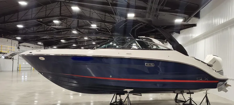 Slide: The Image of 2024 Sea Ray SLX 260 Outboard boat in a spacious indoor showroom. - 0