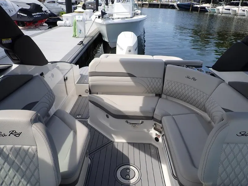 Slide: The Image of 2024 Sea Ray SLX 260 Outboard boat interior with luxurious seating at marina. - 15