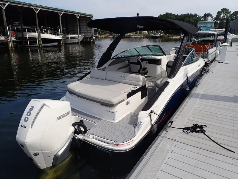 Slide: The Image of 2024 Sea Ray SLX 260 Outboard boat docked at marina with Mercury engine. - 9
