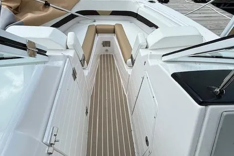 Slide: The Image of 2023 Edgewater 230 CX boat interior with white and tan seating, sleek design. - 10
