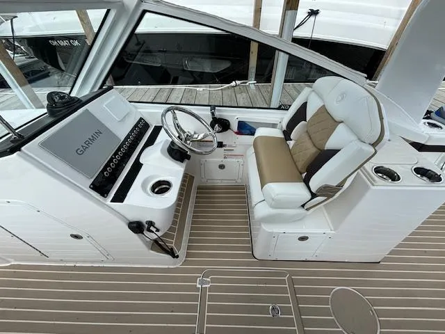 Slide: The Image of 2023 Edgewater 230 CX boat interior with Garmin dashboard and comfortable seating. - 3